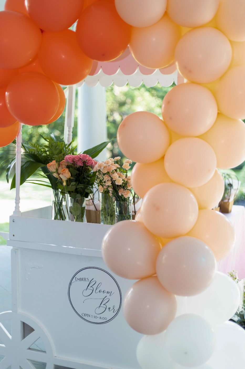 Peach balloon arch over Ember's Bloom Bar cart