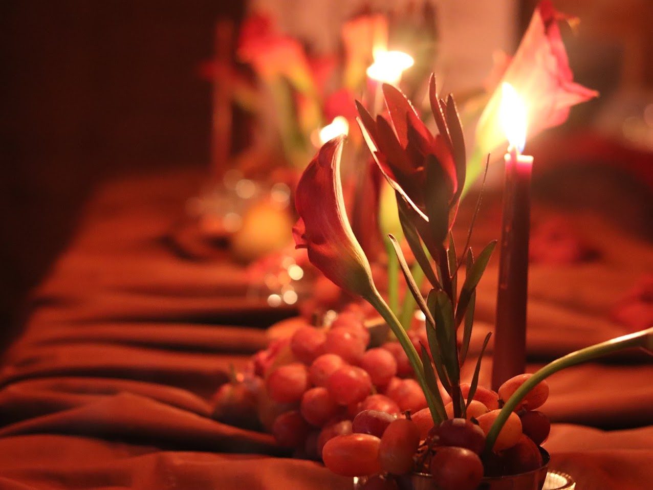 Calla lily and grape centerpiece by candlelight