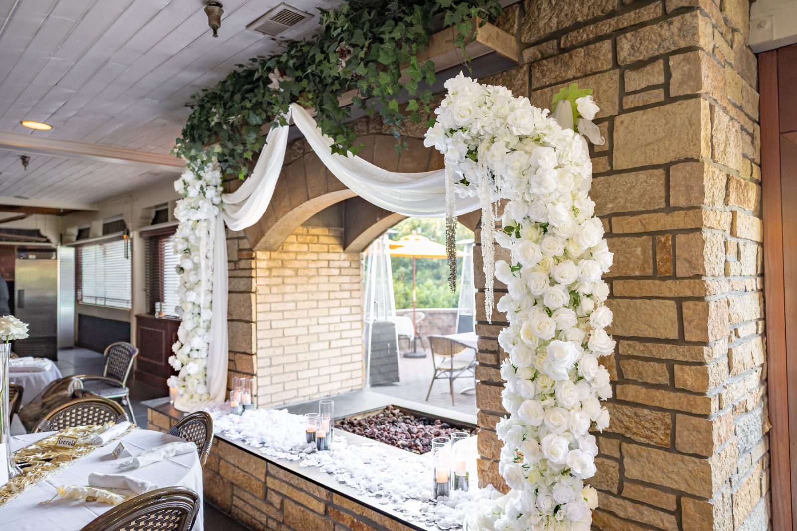 Cascading ivory rose archway over a stone fireplace